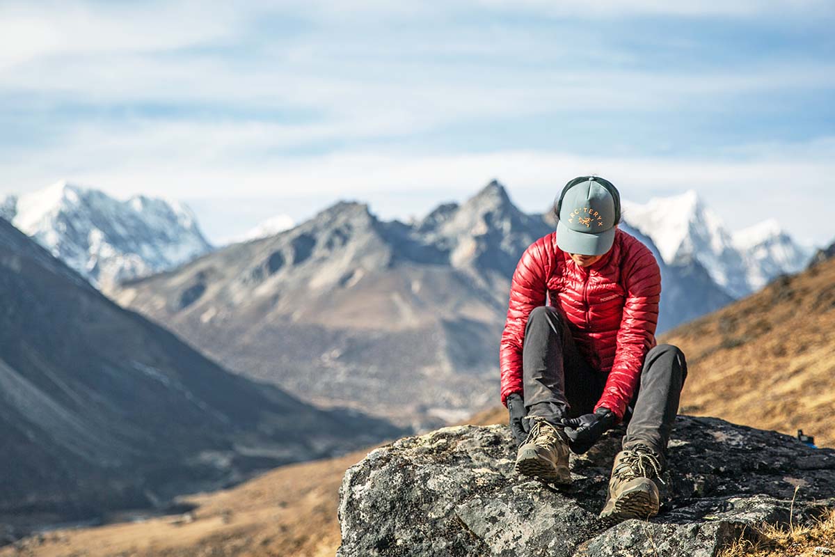 Lacing up women's hiking boot in mountains